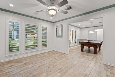 The floor plan provides a versatile space for fun and entertainment, with large windows offering views of the mature yard and lush landscaping.