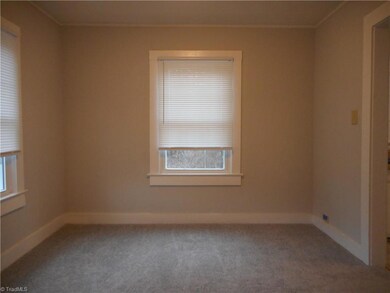 Dining Room: Room features include carpet flooring, fresh paint, crown molding and two windows for natural lighting. The living room is behind us and the kitchen is to the right side.