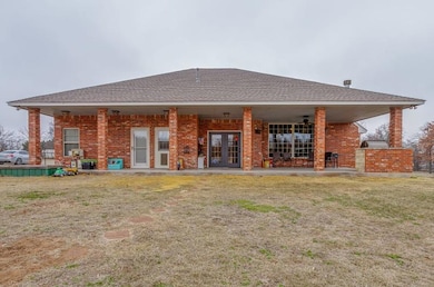 Rear view of house featuring a yard and french doo