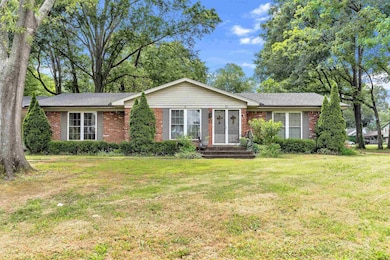 Ranch-style house featuring brick siding and a front yard