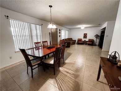 Dining area featuring a textured ceiling and light tile patterned flooring