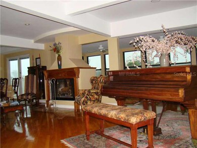 Living Room - Surrounded by glass the living room capitalizes on the view of the park & Tampa Bay. It features Gleaming solid oak hardwood floors and a wood burning fireplace surrounded by an antique Oak mantle.