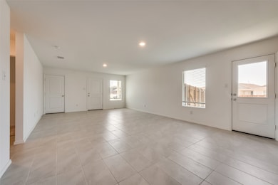 Foyer entrance with light tile patterned floors and recessed lighting