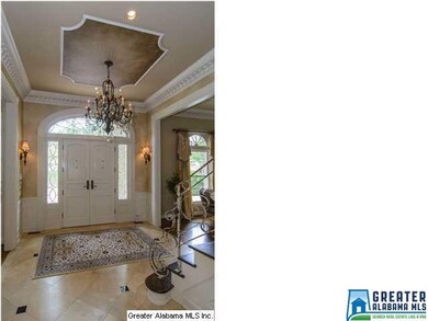 Spacious foyer has a decorative ceiling with denti