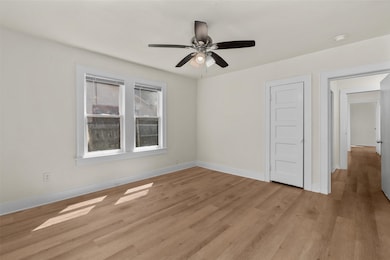 Empty room with light wood finished floors and ceiling fan