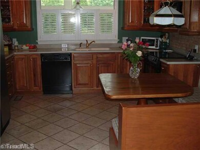 Kitchen. This kitchen offers top of the line appliances, crown moldings, tile flooring, solid countertops, backsplash, pantry, plantation shutters and banquette.
