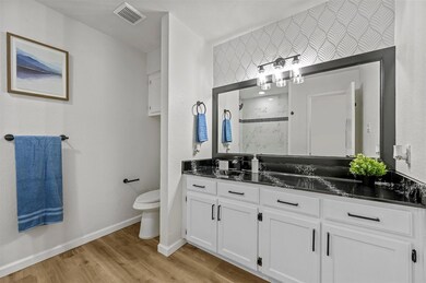 Bathroom featuring walk in shower, vanity, toilet,