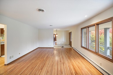 Living room features a large picture window and hardwood floors.
