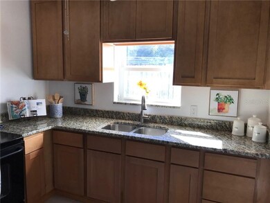 Kitchen with granite counter tops with bright window.