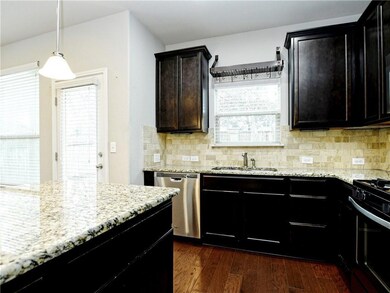 Kitchen with range with gas stovetop, a sink, dis