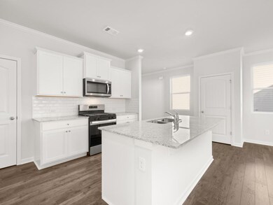 Elston kitchen with stainless steel appliances and white shaker cabients with crown molding