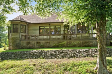 Back of home with full length porch overlooking grape vines, blueberries & blackberries 