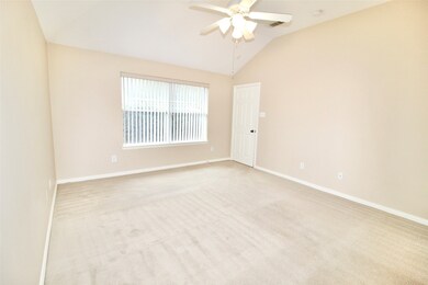 Primary bedroom features high ceilings and ceiling fan!