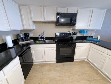 Kitchen featuring dark countertops, black applianc