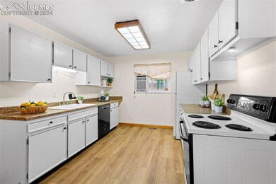 Kitchen with white electric range, light hardwood 