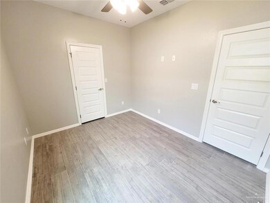 Empty room with visible vents, baseboards, a ceiling fan, and wood finished floors