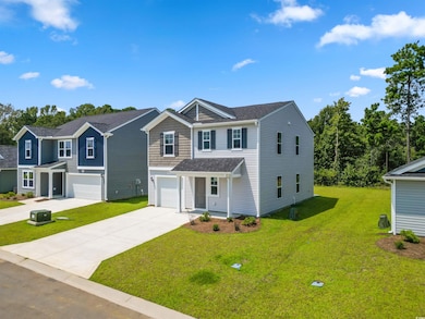 View of front facade featuring a garage and a front yard