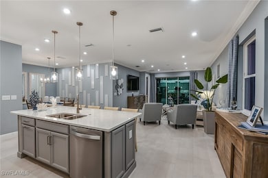 Kitchen with crown molding, light stone countertops, dishwasher, a kitchen island with sink, and pendant lighting
