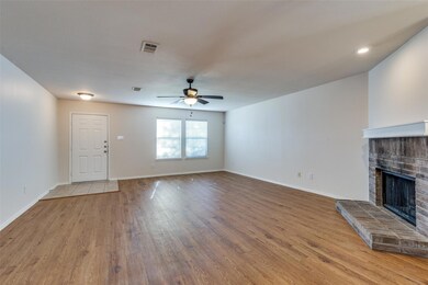 Living room featuring a brick fireplace, ceiling f