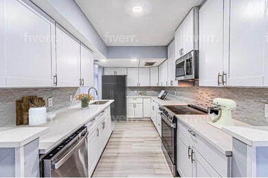 Kitchen with sink, light stone counters, appliance