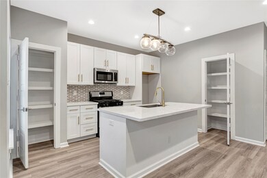 Kitchens have crisp white cabinetry & 2 pantries