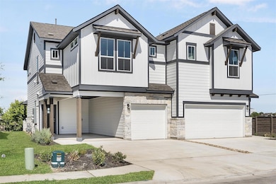View of front facade featuring a garage, stone si