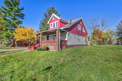 View of front of property with covered porch, a front lawn, and a chimney
