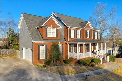 View of front of home with covered porch, a garage, brick siding, concrete driveway, and roof with shingles