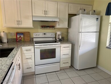 Kitchen with light stone counters, white appliance