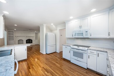 Kitchen - hardwood flooring, white appliances and