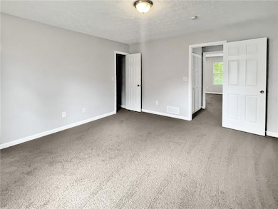 Unfurnished bedroom featuring a textured ceiling, 