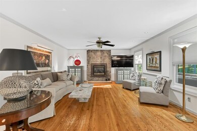 Light & bright family room has exposed hardwood floors, newer windows, & gas fireplace.