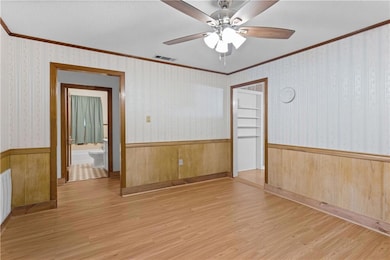 Spare room featuring crown molding, ceiling fan, a