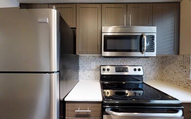 Kitchen featuring backsplash and stainless steel a