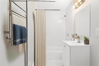 Bathroom featuring shower / bath combo with shower curtain and vanity