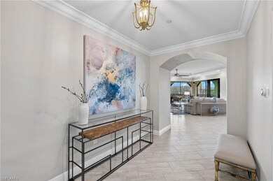 Foyer with arched walkways, crown molding, and a n