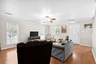 Living area with ornamental molding, light wood-st