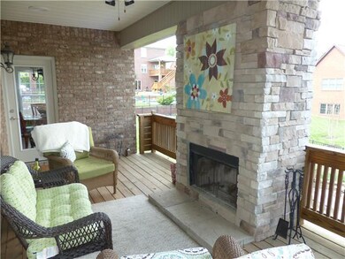 The covered deck has a fireplace and overlooks the pool and backyard. This is a great place to relax! 