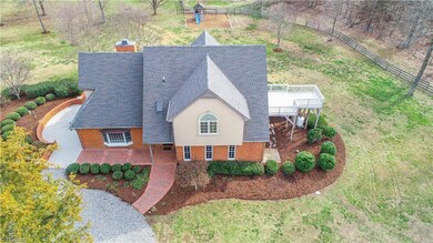 This front elevation aerial offers a view of the multiple outdoor living spaces. Enjoy your morning coffee from the owner's deck (FRESH stain applied 2020) or an afternoon siesta on the patio.