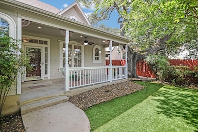 View of exterior entry featuring covered porch, ceiling fan, and roof with shingles