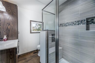 Bathroom featuring hardwood flooring, an enclosed 