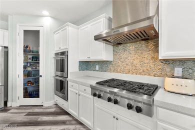 Kitchen featuring wall chimney range hood, applian