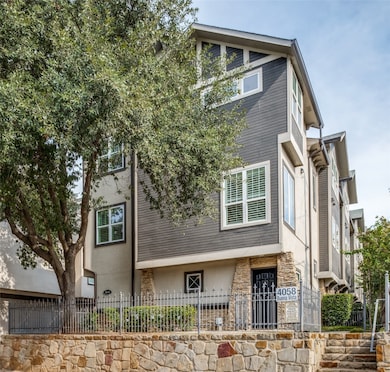 View of side of property with a fenced front yard and stone siding