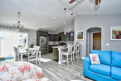 Living room with ceiling fan with notable chandeli