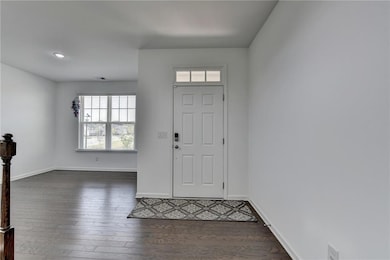 Foyer with dark wood-type flooring, baseboards, an