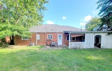 Rear view of house with central AC and a lawn