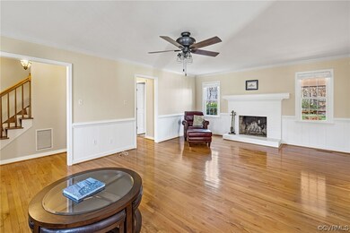 Family room with hardwood floor, ceiling fan, crown molding and wainscoting!