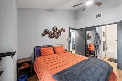 Bedroom featuring wood finished floors, high vaul