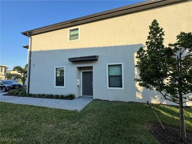 Rear view of house featuring a lawn and stucco sid