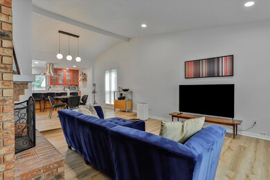 Living room featuring a brick fireplace, light woo